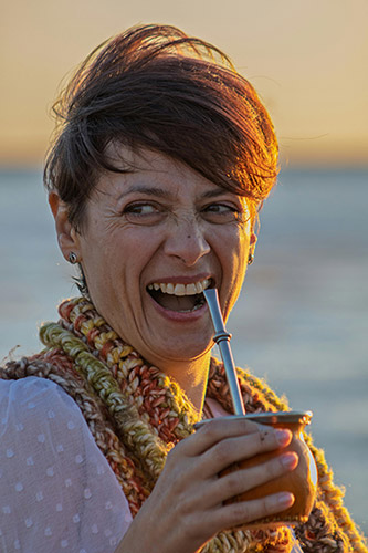 Femme dégustant un maté traditionnel dans une calebasse avec une bombilla, symbole de bien-être et de pause naturelle